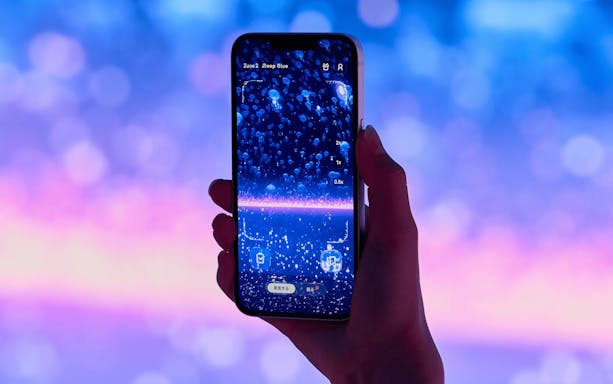 Smartphone displaying jellyfish in Wonderia YOKOHAMA exhibit.
