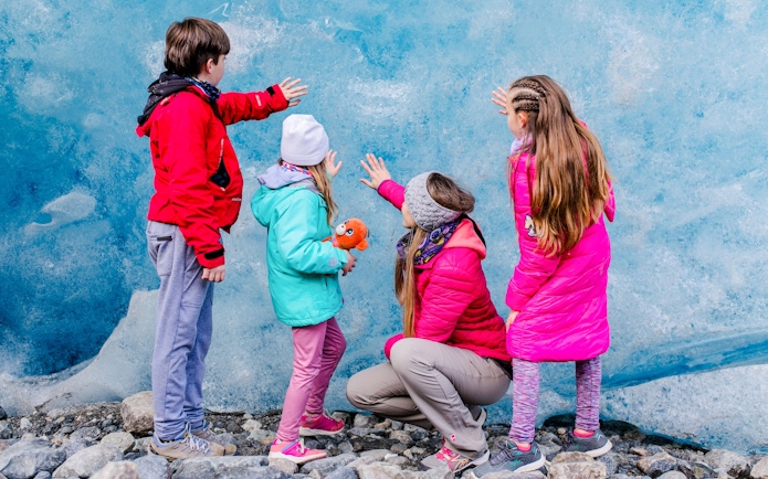 Guests touching Perito Moreno Glacier wall during guided tour in Azul, Argentina.