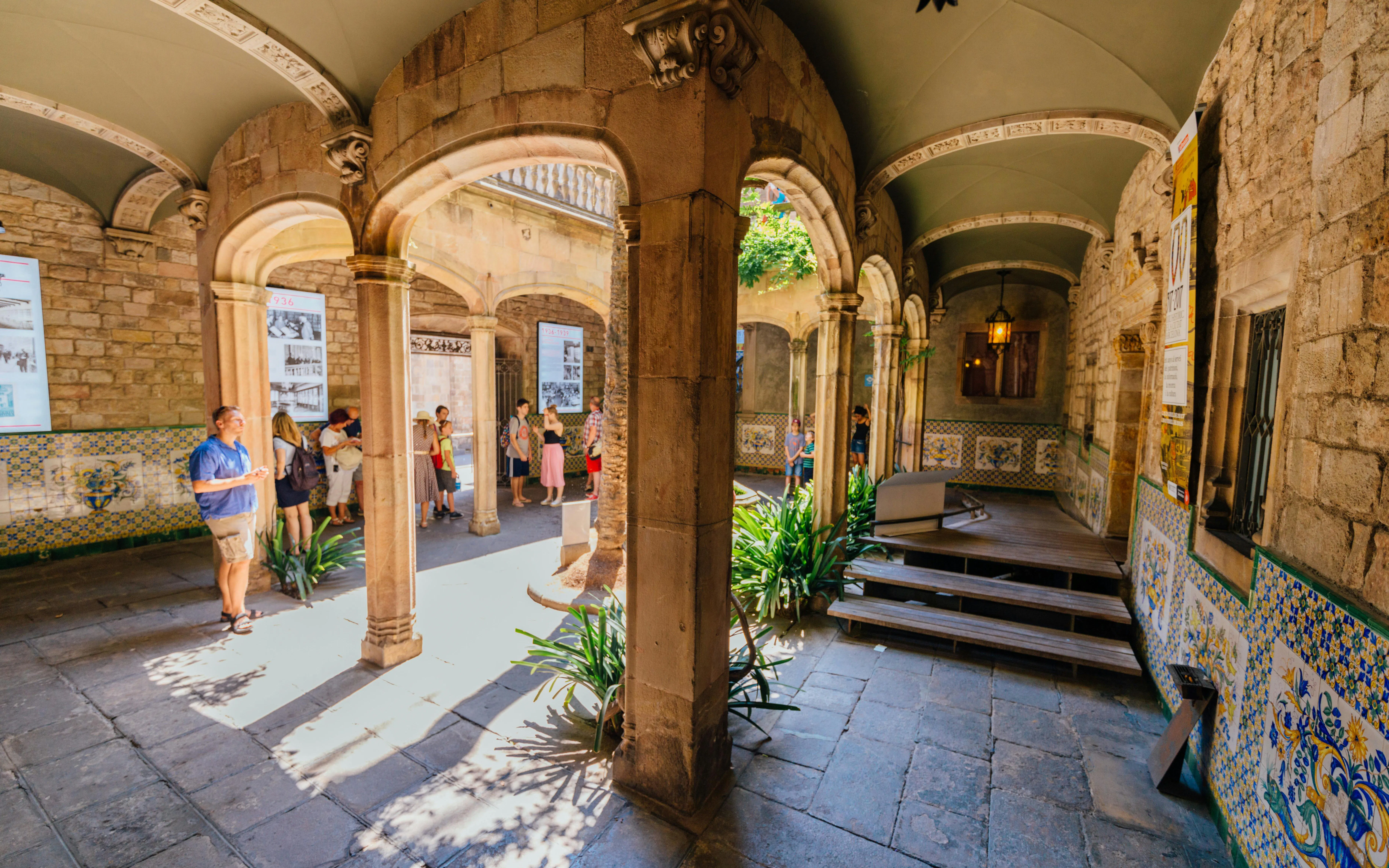 Visitors exploring historic courtyard in the Gothic Quarter, Barcelona.