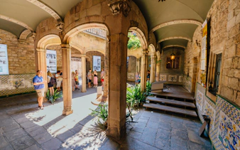 Visitors exploring historic courtyard in the Gothic Quarter, Barcelona.