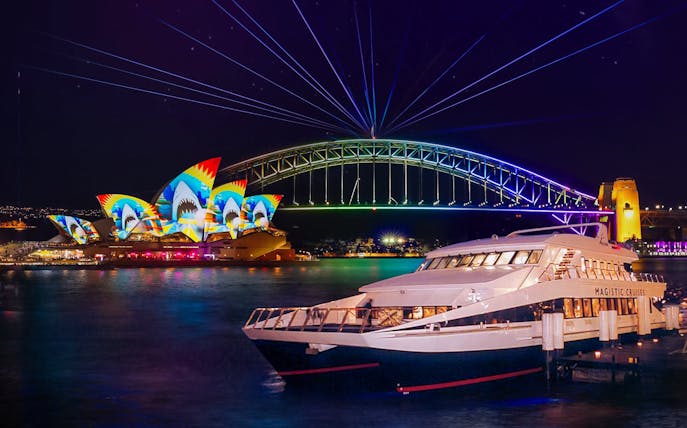 Sydney Opera House and Harbour Bridge illuminated during Vivid Sydney cruise.