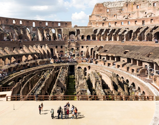 Colosseum arena floor with tourists on a semi-private tour, Rome.