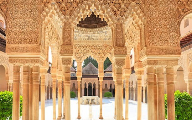 Courtyard arches and fountain at the Yard of the Lions, Alhambra, Granada, Spain.