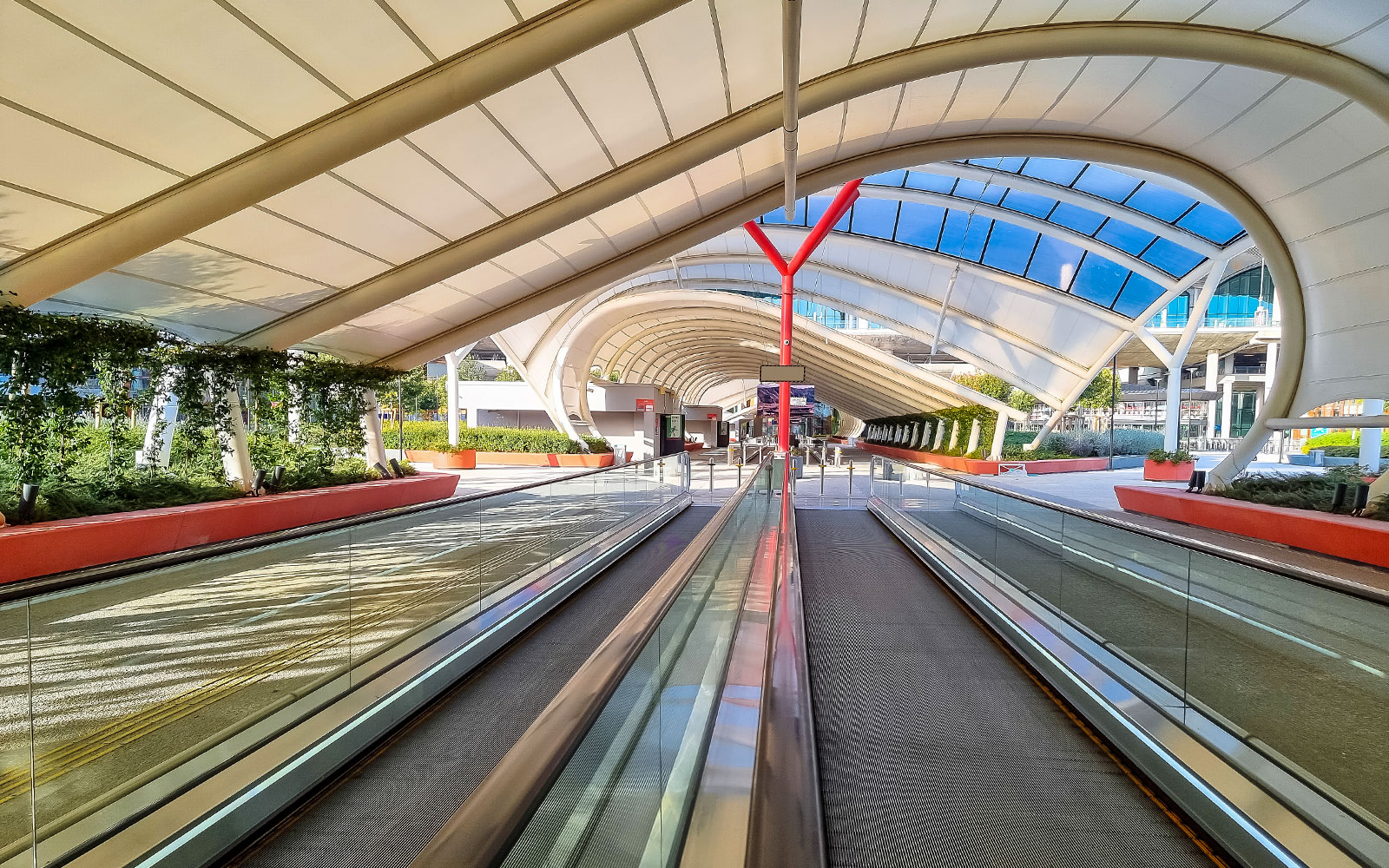 Covered walkway with moving sidewalks at Istanbul Airport shuttle bus area.