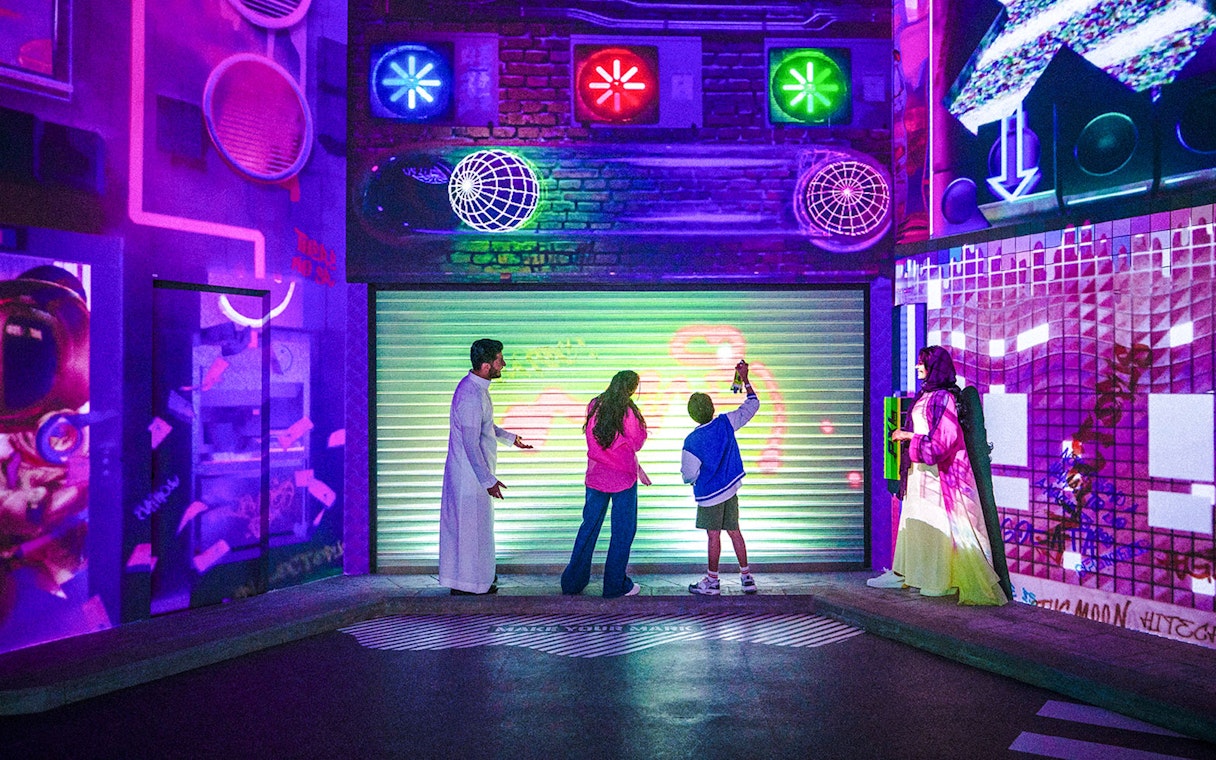 Visitors interacting with colorful digital art at House of Hype exhibit.