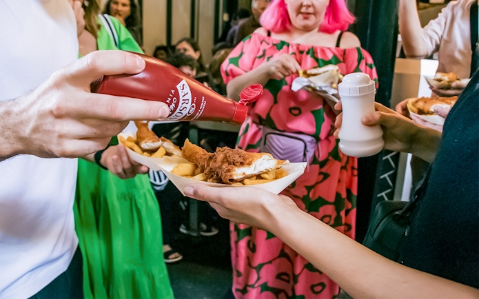 People enjoying fish and chips at Borough Market on the Bankside Food Tour in London.