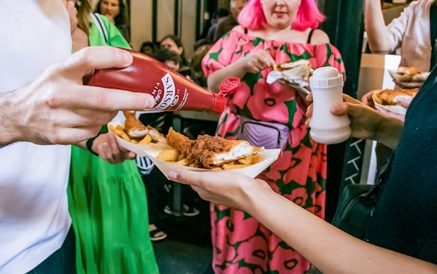People enjoying fish and chips at Borough Market on the Bankside Food Tour in London.