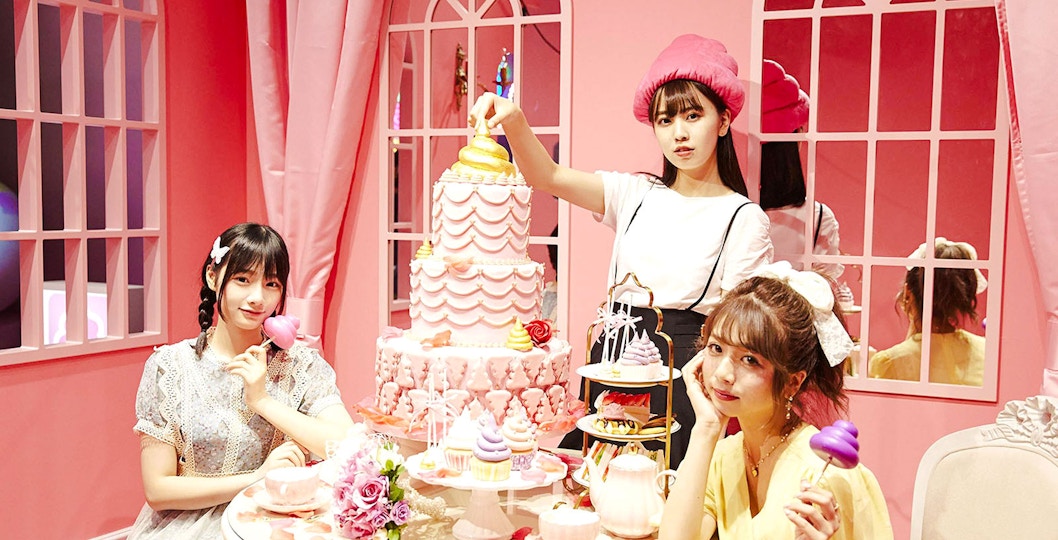 Visitors enjoy poop-themed desserts in a pink-walled room at the Unko Museum.