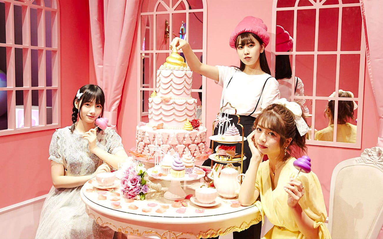 Visitors enjoy poop-themed desserts in a pink-walled room at the Unko Museum.