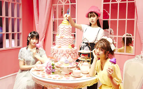 Visitors enjoy poop-themed desserts in a pink-walled room at the Unko Museum.