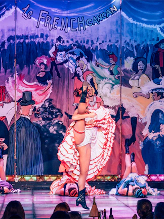 Cabaret performers on stage at Nouvelle Eve in Paris, featuring vibrant costumes and dynamic choreography.