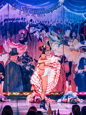 Cabaret performers on stage at Nouvelle Eve in Paris, featuring vibrant costumes and dynamic choreography.
