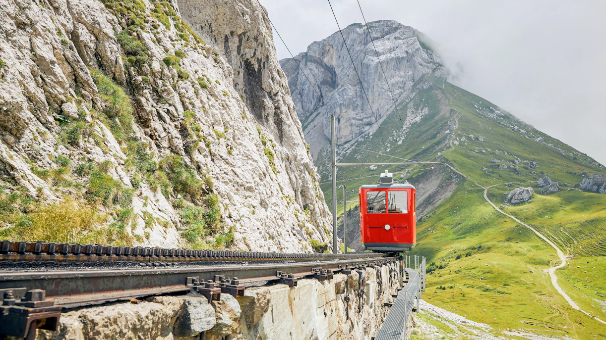 Red cogwheel train ascending Mount Pilatus near Alpnachstad, Lucerne.
