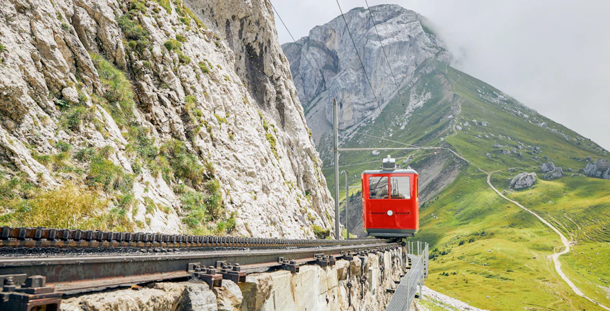 Red cogwheel train ascending Mount Pilatus near Alpnachstad, Lucerne.