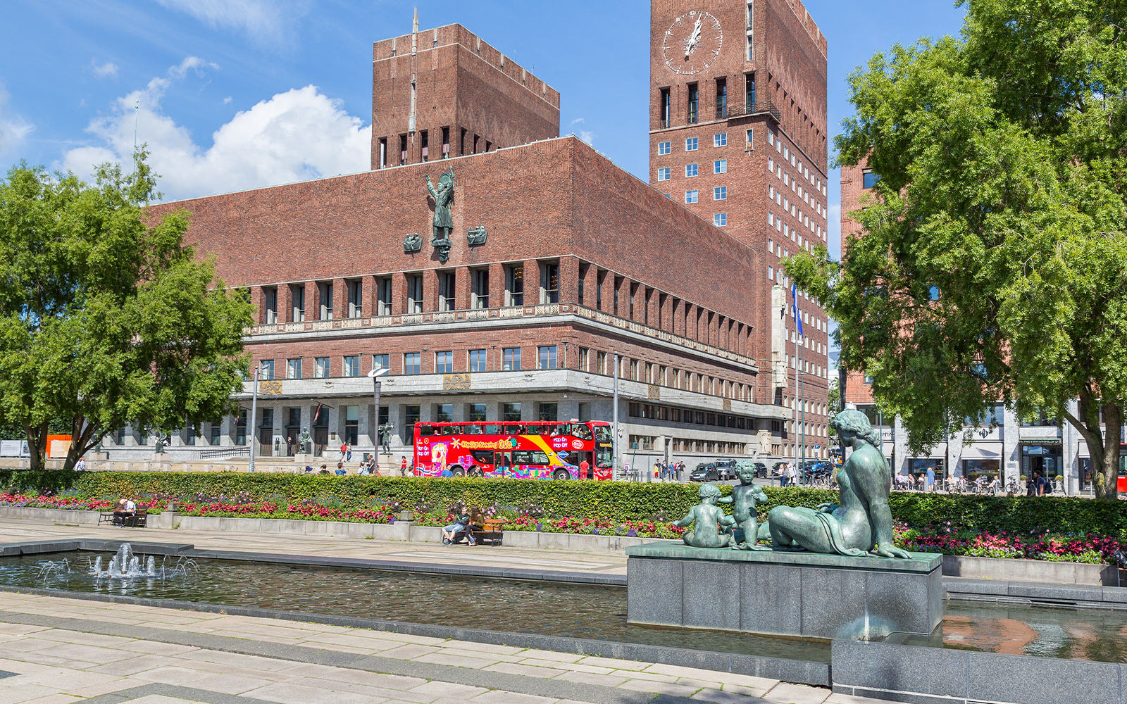 Oslo City Hall with a red hop-on hop-off bus in front, part of the Oslo sightseeing tour.