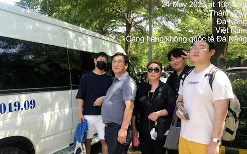 Group of travelers beside a van for Da Nang airport transfer service to Hoi An.