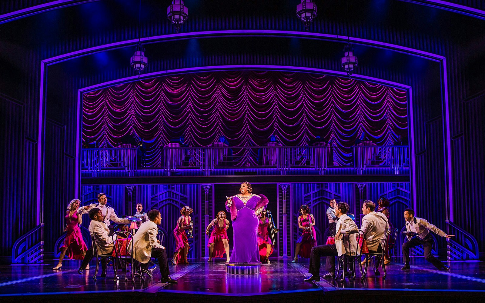 Stage performance of "Some Like it Hot" with actors in vibrant costumes.