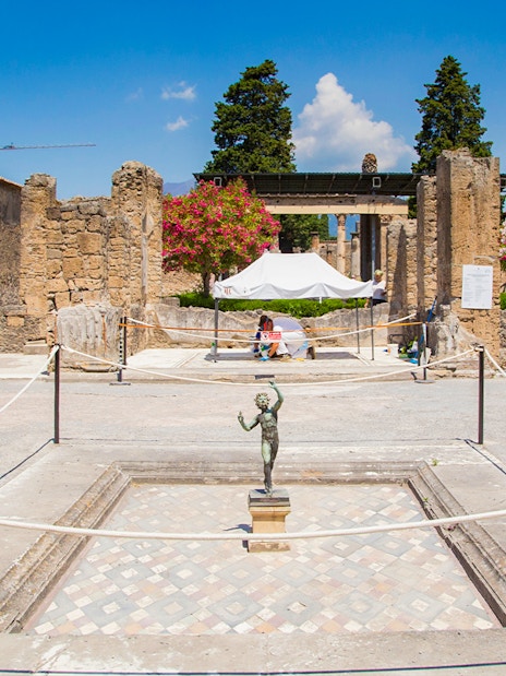 House of the Faun courtyard with bronze statue, Pompeii ruins.