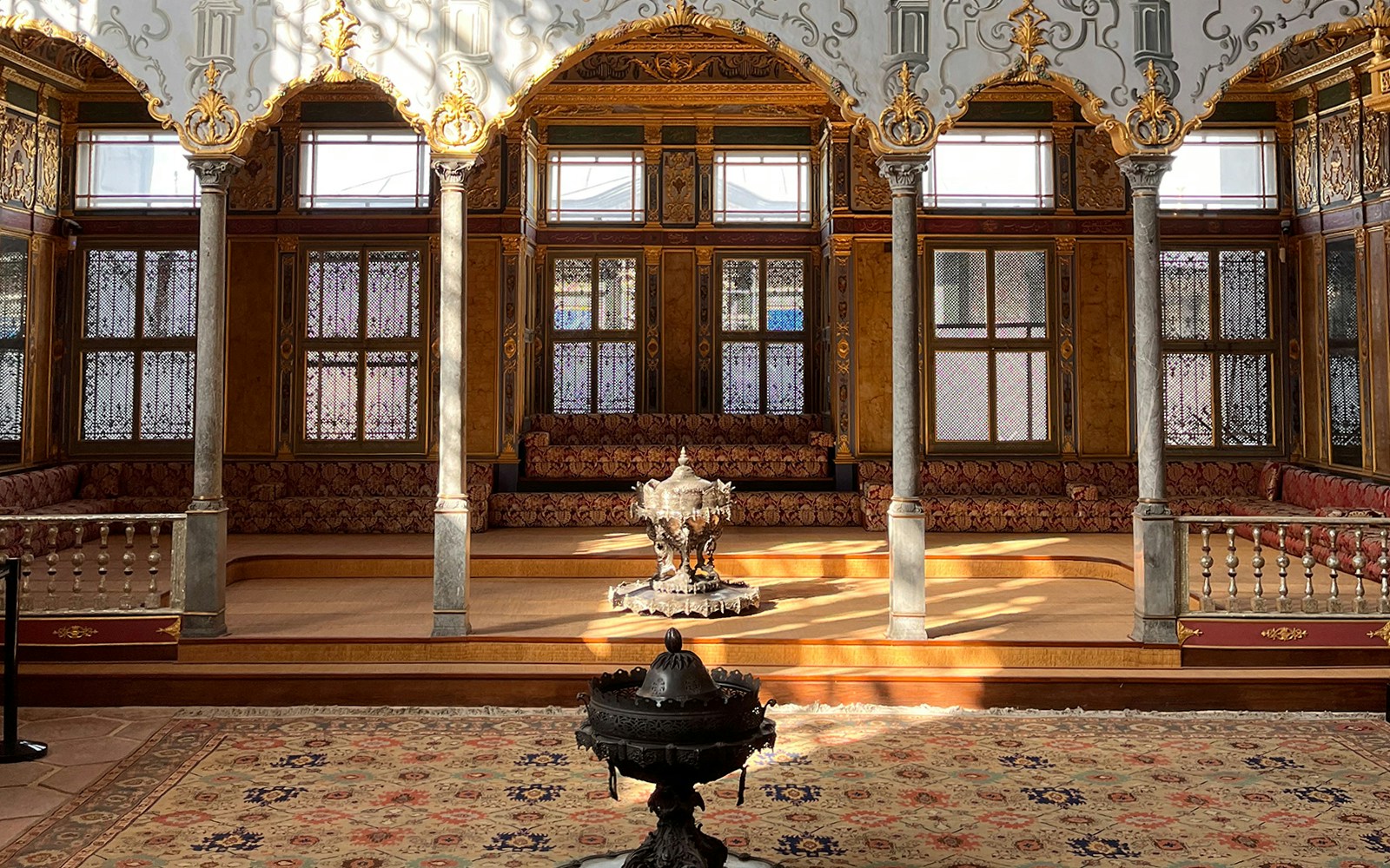Visitors exploring the historic Topkapi Palace Museum courtyard in Istanbul.