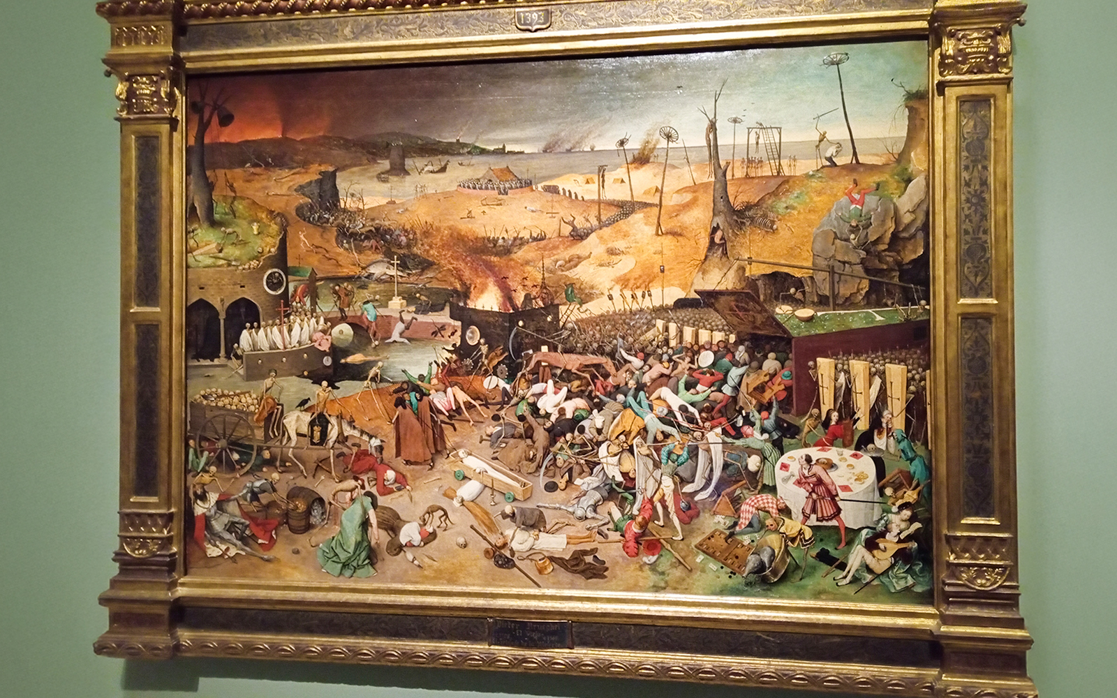 Pieter Bruegel's "The Triumph of Death" painting at Prado Museum, depicting chaotic medieval scene.