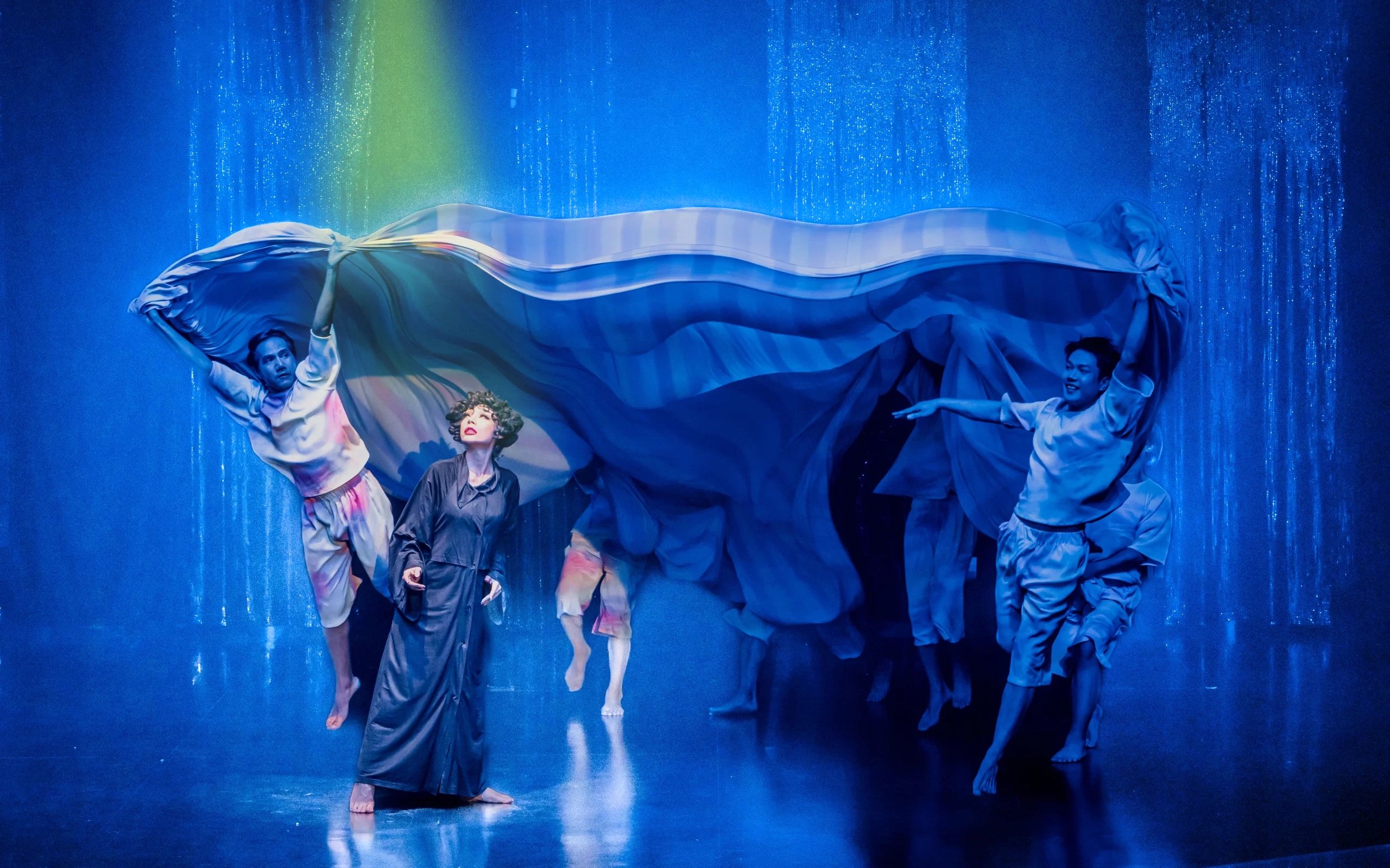 Performers on stage at Calypso Cabaret show in Bangkok, with vibrant costumes and dramatic lighting.