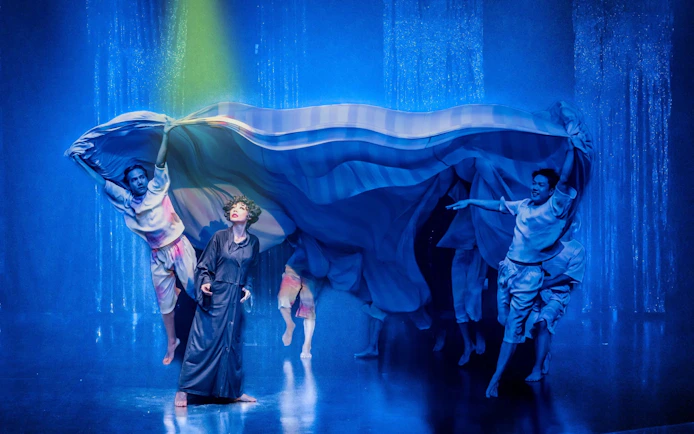 Performers on stage at Calypso Cabaret show in Bangkok, with vibrant costumes and dramatic lighting.