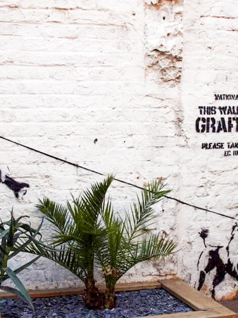 Street art of a policeman and dog on Brick Lane, London, featured on the food tour.