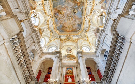 Royal Palace of Madrid interior with ornate ceiling and grand staircase.
