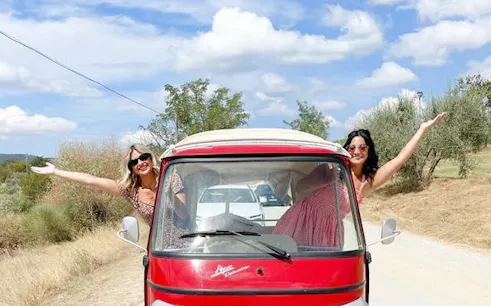 Tuk Tuk on Tuscany road with two people enjoying countryside views.