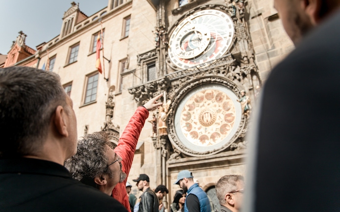Tourists observing the Prague Astronomical Clock during Old Town tour.