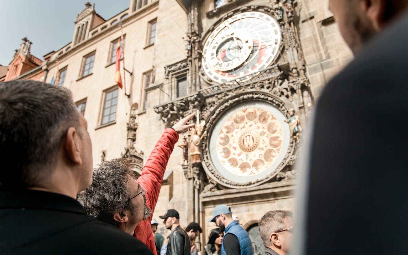 Tourists observing the Prague Astronomical Clock during Old Town tour.