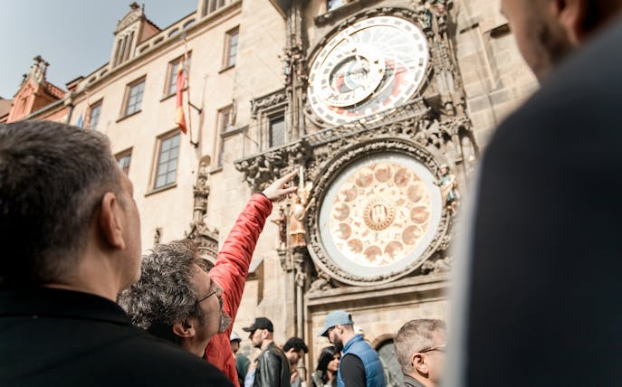 Tourists observing the Prague Astronomical Clock during Old Town tour.