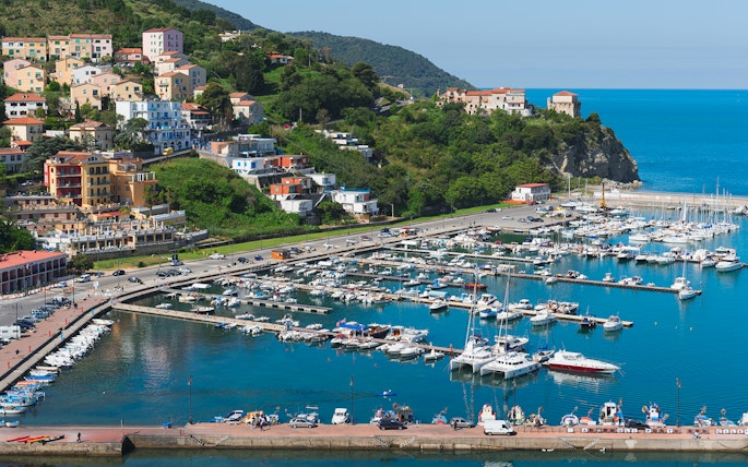 Amalfi Coast marina with colorful hillside buildings and boats docked in the harbor.