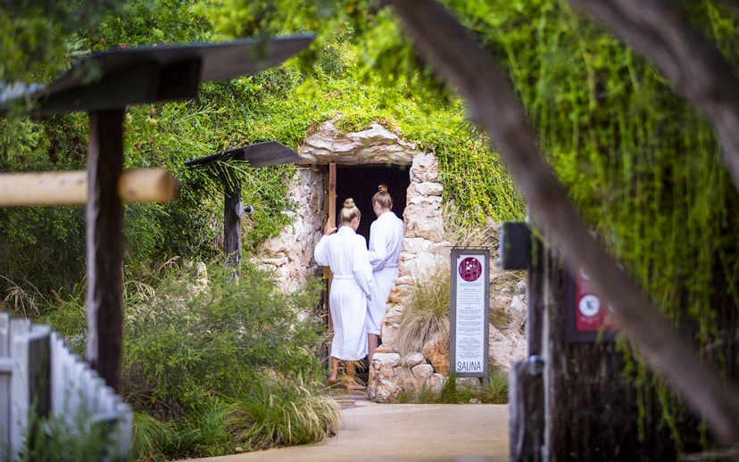 Visitors entering a stone sauna at Peninsula Hot Springs, Australia.