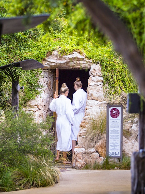 Visitors entering a stone sauna at Peninsula Hot Springs, Australia.