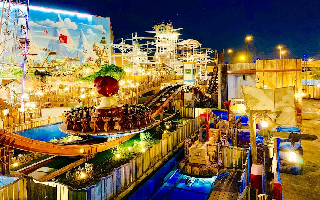 Disco coaster ride at night in Angry Birds World Theme Park, featuring vibrant lights and themed decor.