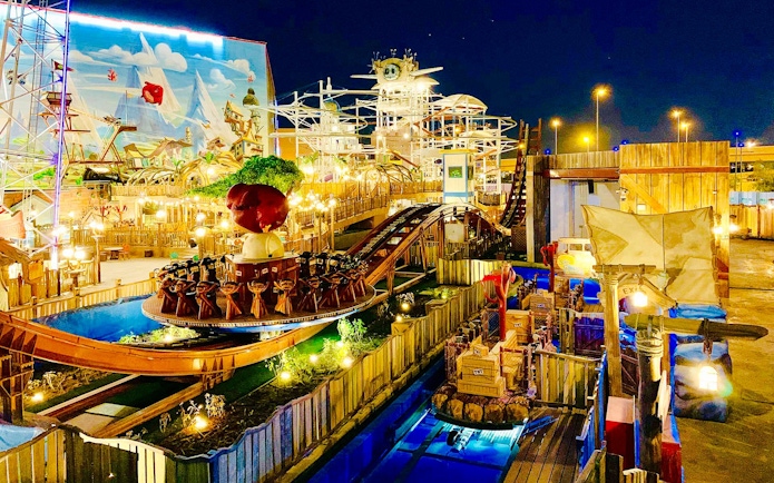 Disco coaster ride at night in Angry Birds World Theme Park, featuring vibrant lights and themed decor.