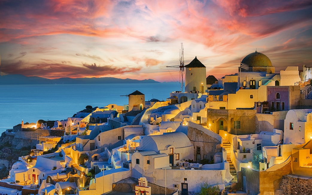 Oia village at sunset with iconic windmills and sea view, Santorini sightseeing tour.