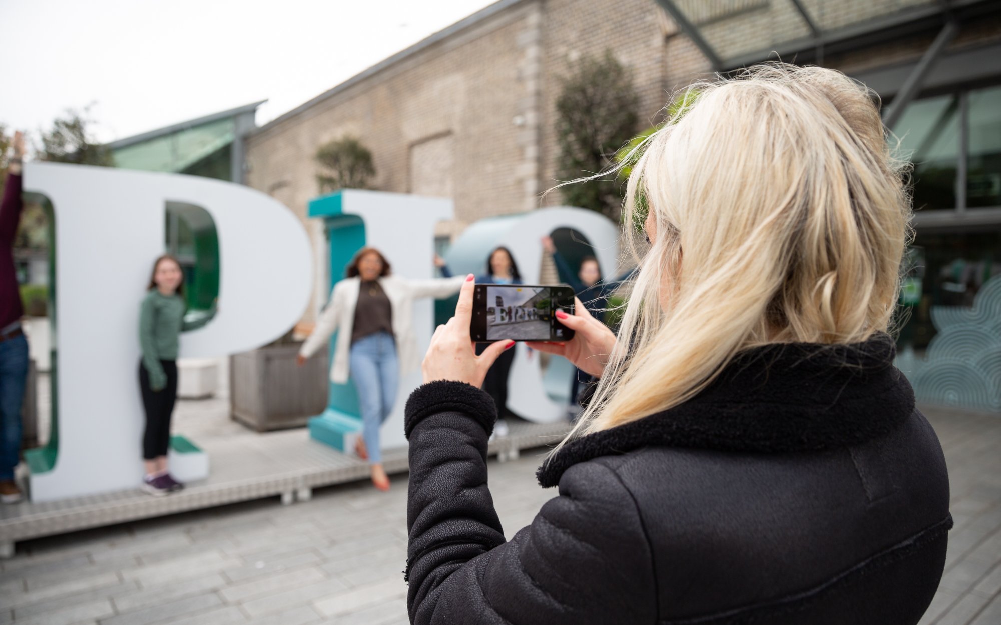 Visitors taking photos at the EPIC Museum entrance in Dublin.