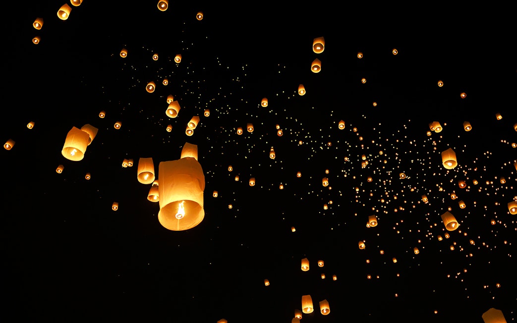 Lanterns floating in the night sky at Chiang Mai Sky Lanterns Festival 2025, Thailand.