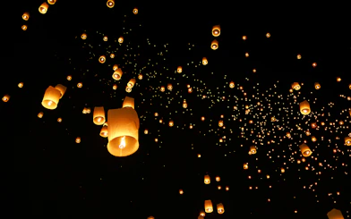 Lanterns floating in the night sky at Chiang Mai Sky Lanterns Festival 2025, Thailand.