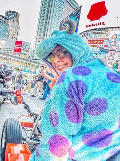 Man in Pikachu costume and woman in Sulley costume in go-karts, Shibuya crossing.