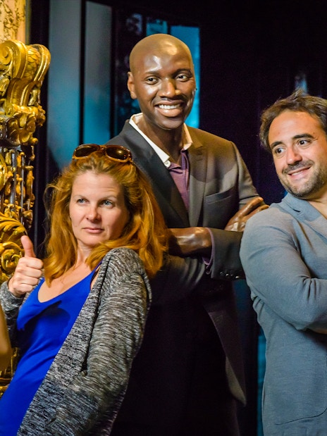 Visitors posing with wax figures at Grévin Wax Museum, Paris.