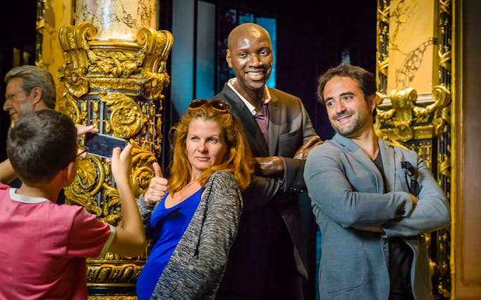 Visitors posing with wax figures at Grévin Wax Museum, Paris.
