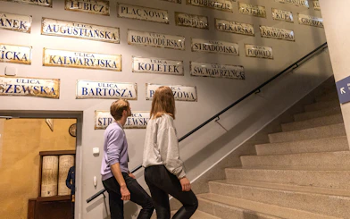 Couple exploring street signs inside Oskar Schindler's Factory, Krakow.