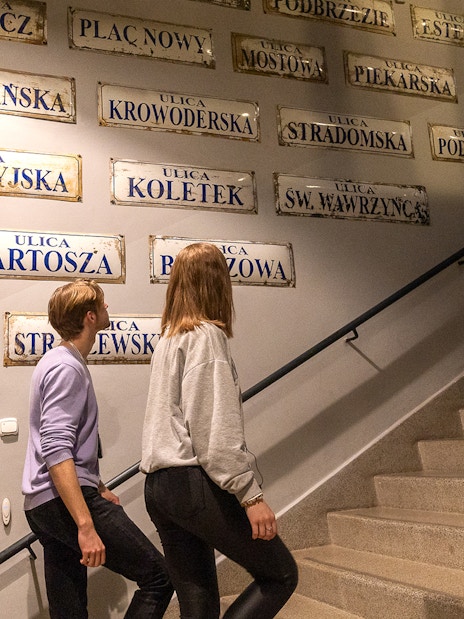 Couple exploring street signs inside Oskar Schindler's Factory, Krakow.