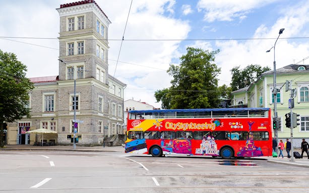 City sightseeing bus on a street in Tallinn near historic buildings.