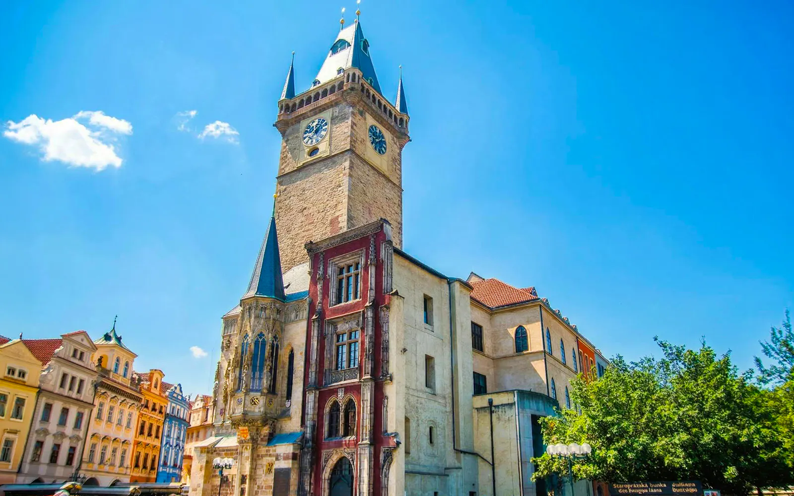 Astronomical Clock tower in Prague's Old Town Square under a clear blue sky.