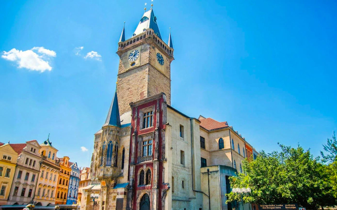 Astronomical Clock tower in Prague's Old Town Square under a clear blue sky.