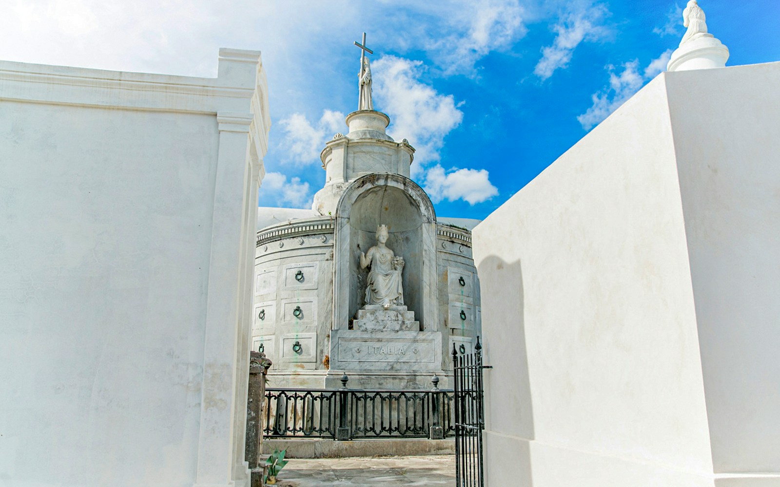 Tomb with statue and cross inside St. Louis Cemetery, New Orleans.